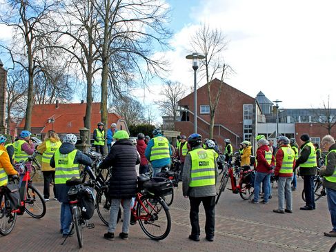 Gruppe von Radfahrern hört einem Vortragenden zu